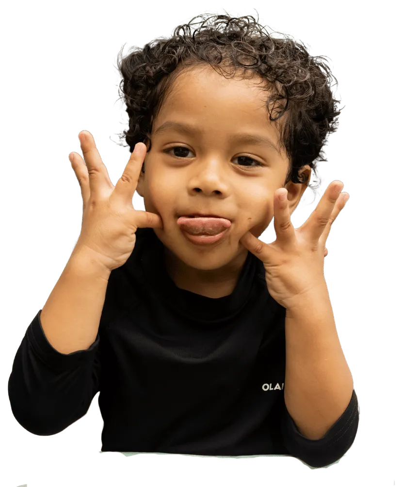 A curly-haired boy pulling a funny face