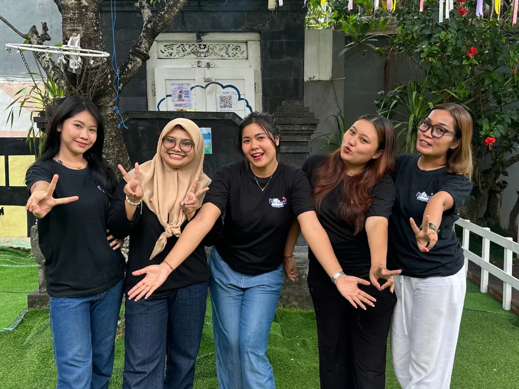 Five Malinki teachers in black Malinki T-shirts in the kindergarten garden